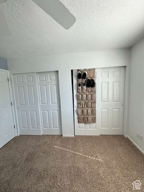 Unfurnished bedroom featuring baseboards, a textured ceiling, ceiling fan, and carpet