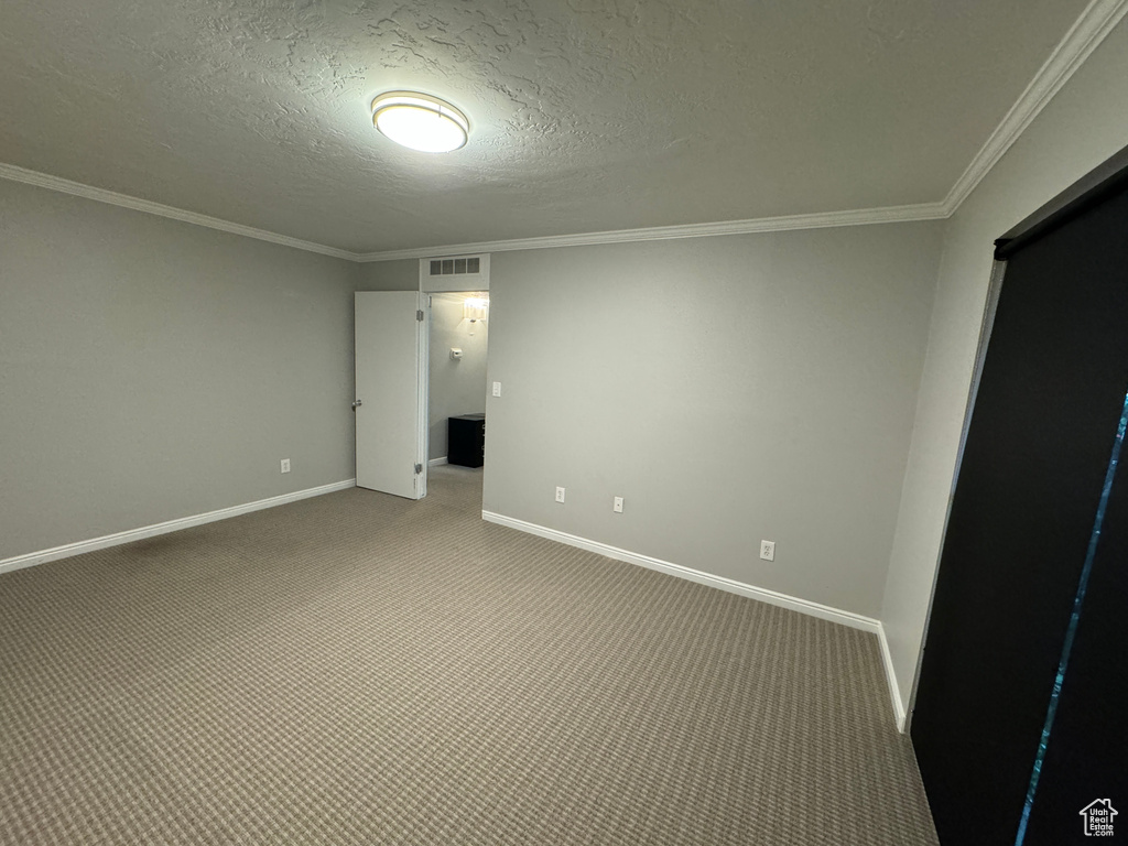 Unfurnished bedroom featuring crown molding, baseboards, visible vents, and carpet