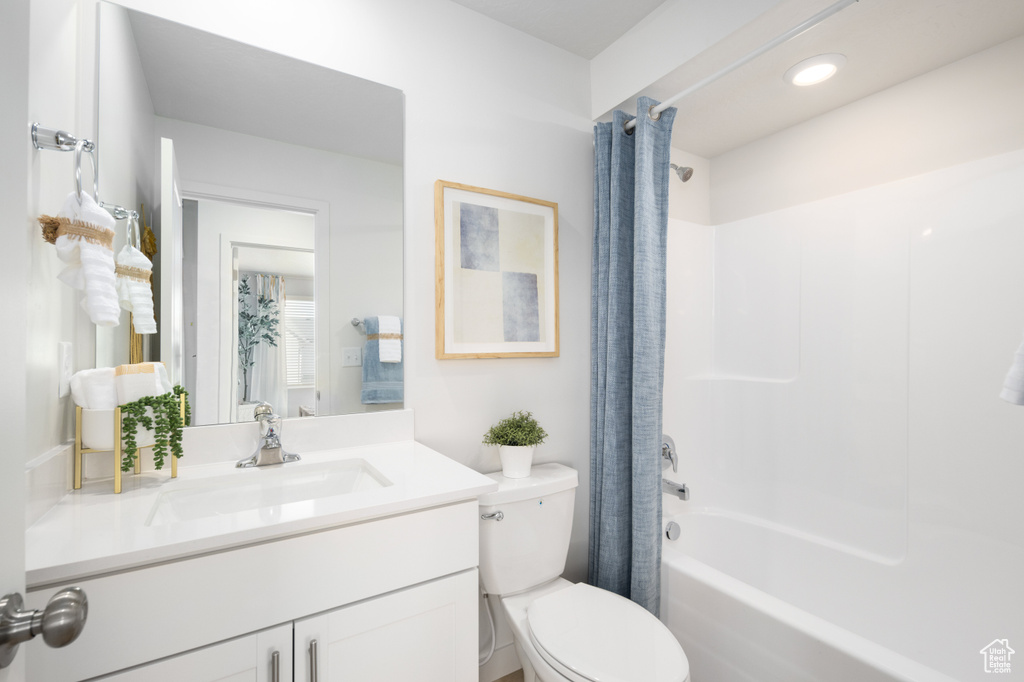Full bathroom featuring vanity, shower / tub combo with curtain, and toilet