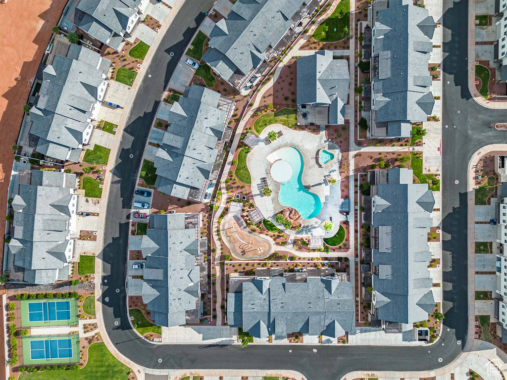 Aerial view of property and surrounding area featuring a pool area and nearby suburban area
