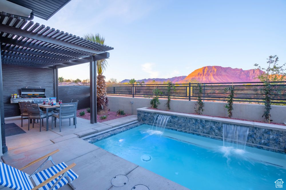 View of pool featuring a patio area, a fenced in pool, a mountain view, a fenced backyard, and a pergola