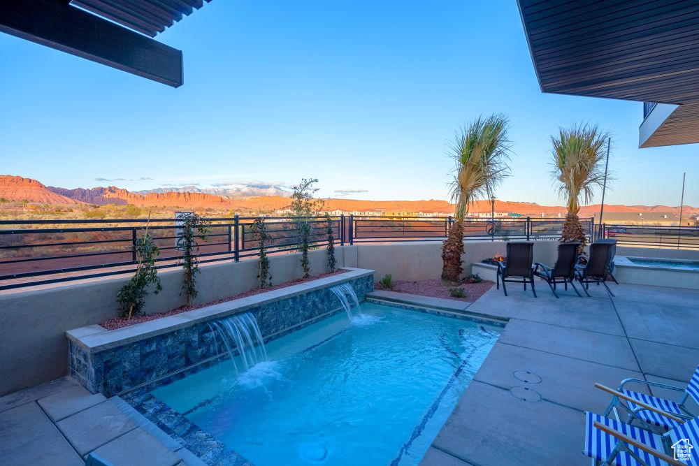 View of pool with a patio, a fenced in pool, a mountain view, and a fenced backyard