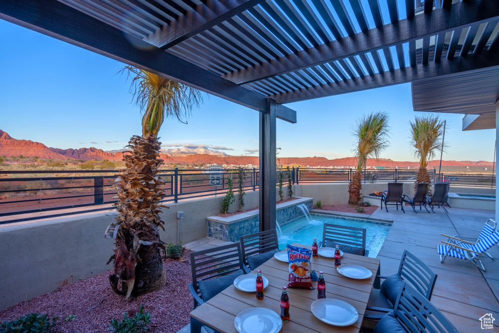 View of patio featuring a fenced in pool, outdoor dining area, a mountain view, and a fenced backyard