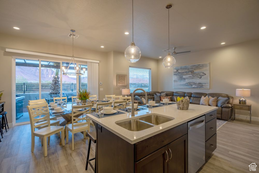 Kitchen with open floor plan, recessed lighting, a sink, light wood-style flooring, and dishwasher