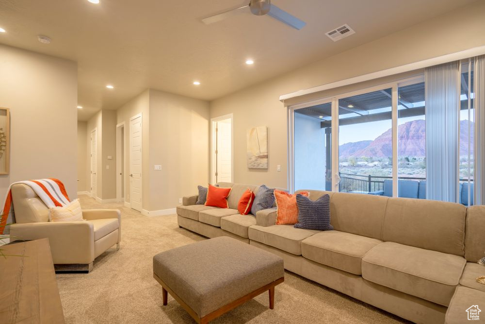 Living room featuring visible vents, ceiling fan, recessed lighting, light colored carpet, and a mountain view