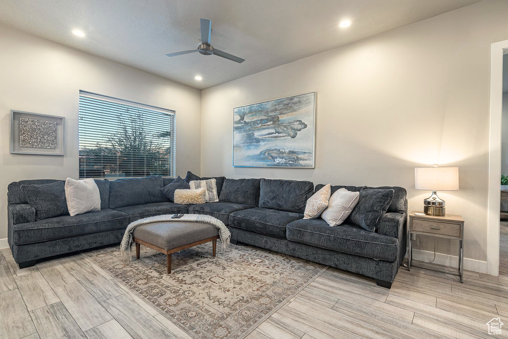 Living room with light wood-type flooring, ceiling fan, recessed lighting, and baseboards