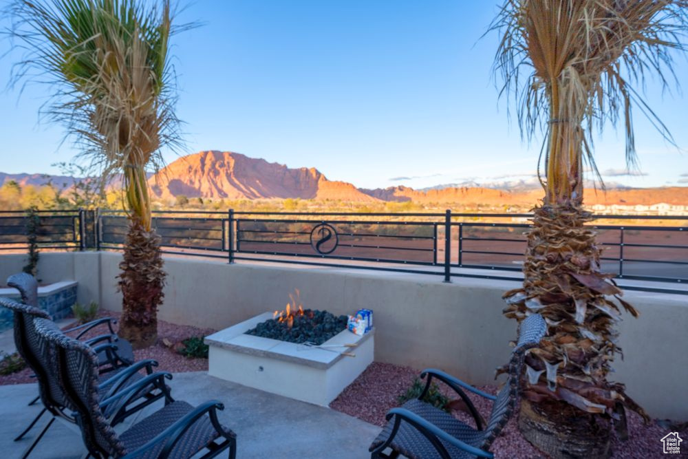 View of patio featuring a fire pit, a mountain view, and fence