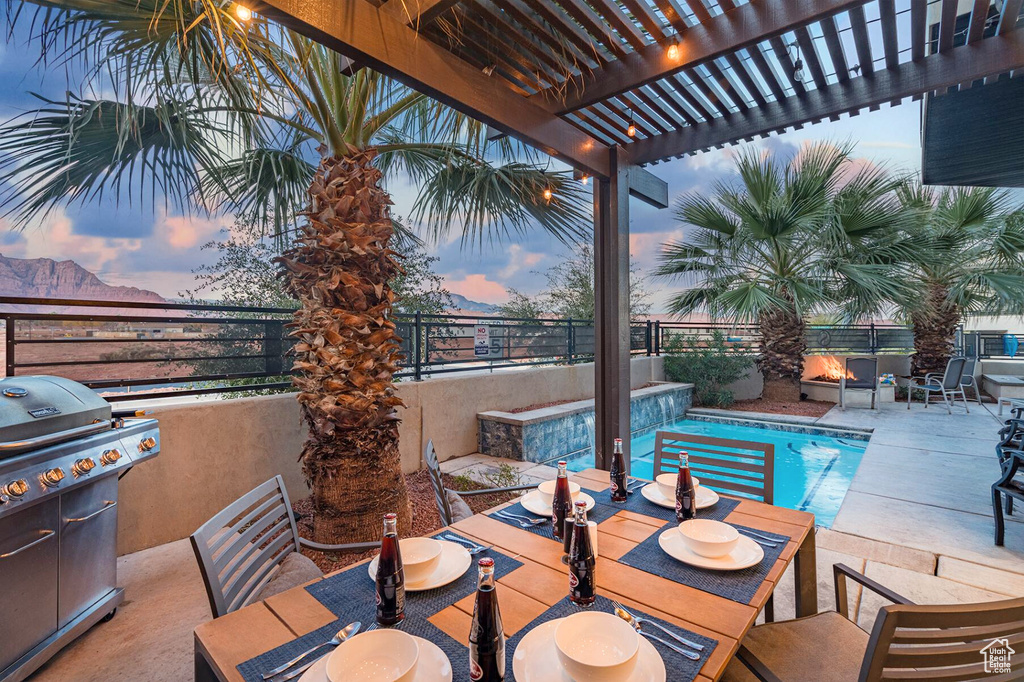 Patio terrace at dusk featuring area for grilling, a fenced backyard, a pergola, and outdoor dining area