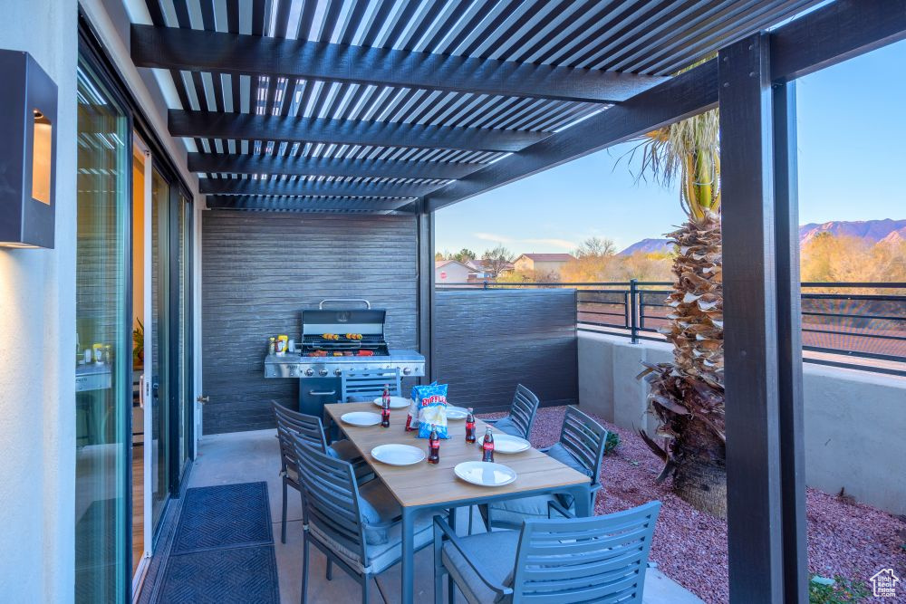 Balcony with a pergola, a grill, and outdoor dining space