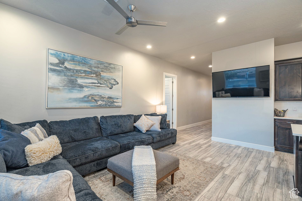 Living room featuring light wood finished floors, recessed lighting, a ceiling fan, and baseboards
