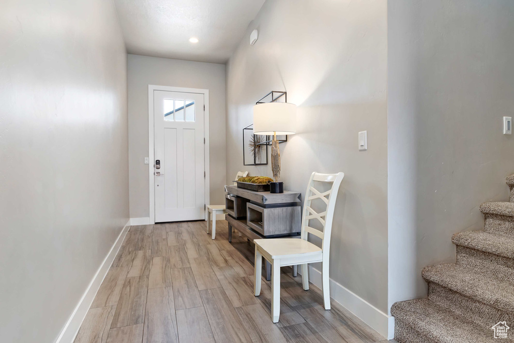Entrance foyer with stairs, wood finished floors, and baseboards