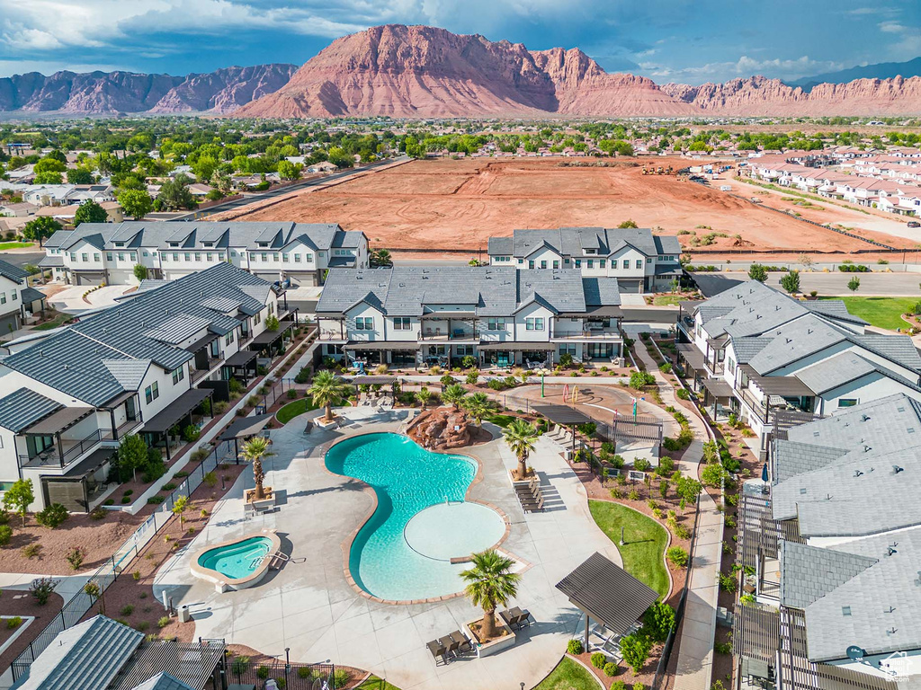 Aerial perspective of suburban area featuring a mountain backdrop and a pool area