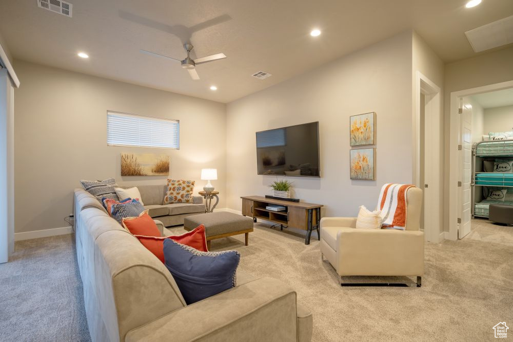 Carpeted living room with visible vents, recessed lighting, and a ceiling fan