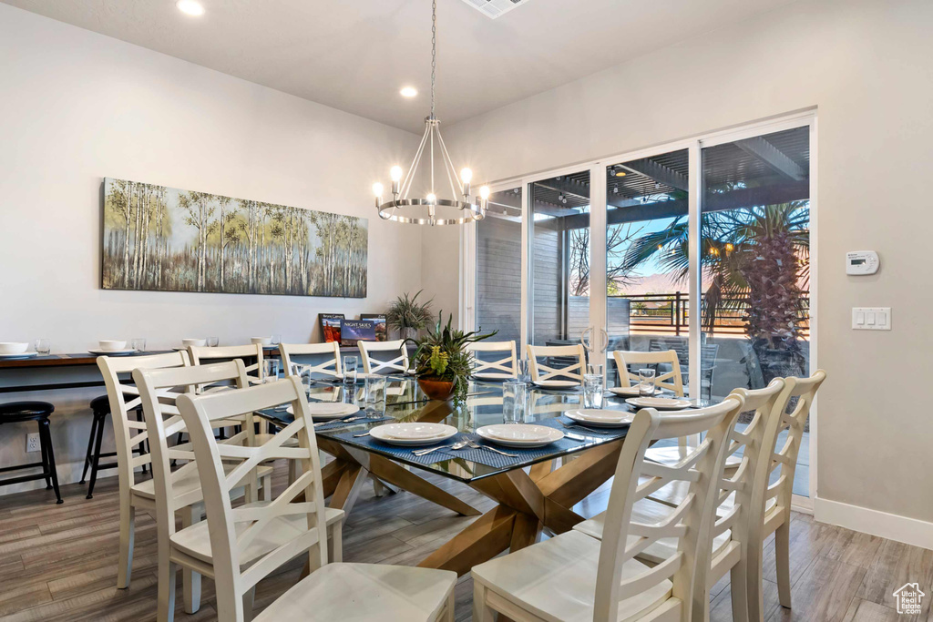 Dining room featuring a chandelier, wood finished floors, recessed lighting, and baseboards