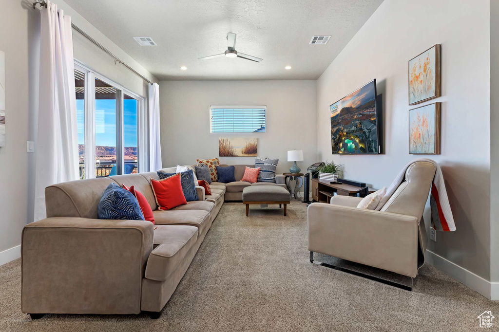 Living room with carpet flooring, ceiling fan, baseboards, and recessed lighting