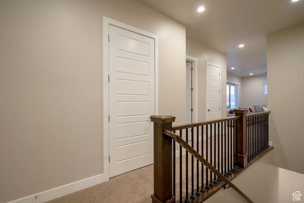 Hallway with recessed lighting, baseboards, an upstairs landing, and carpet