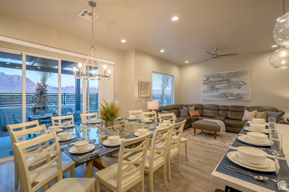 Dining space with visible vents, wood finished floors, recessed lighting, a mountain view, and ceiling fan with notable chandelier