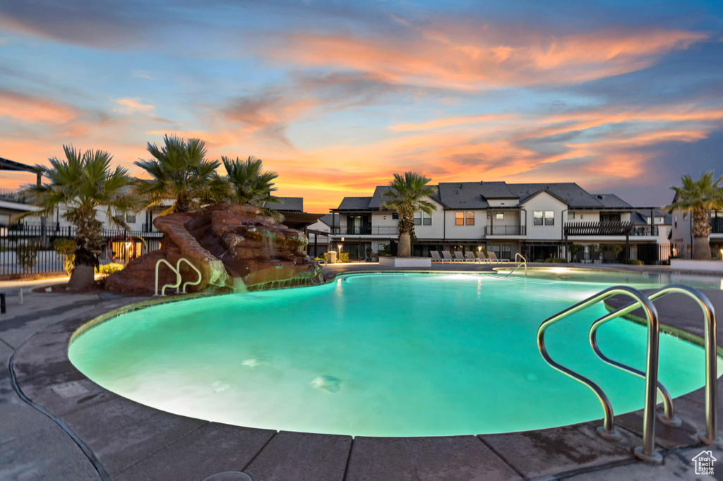 Pool at dusk with a community pool and a residential view