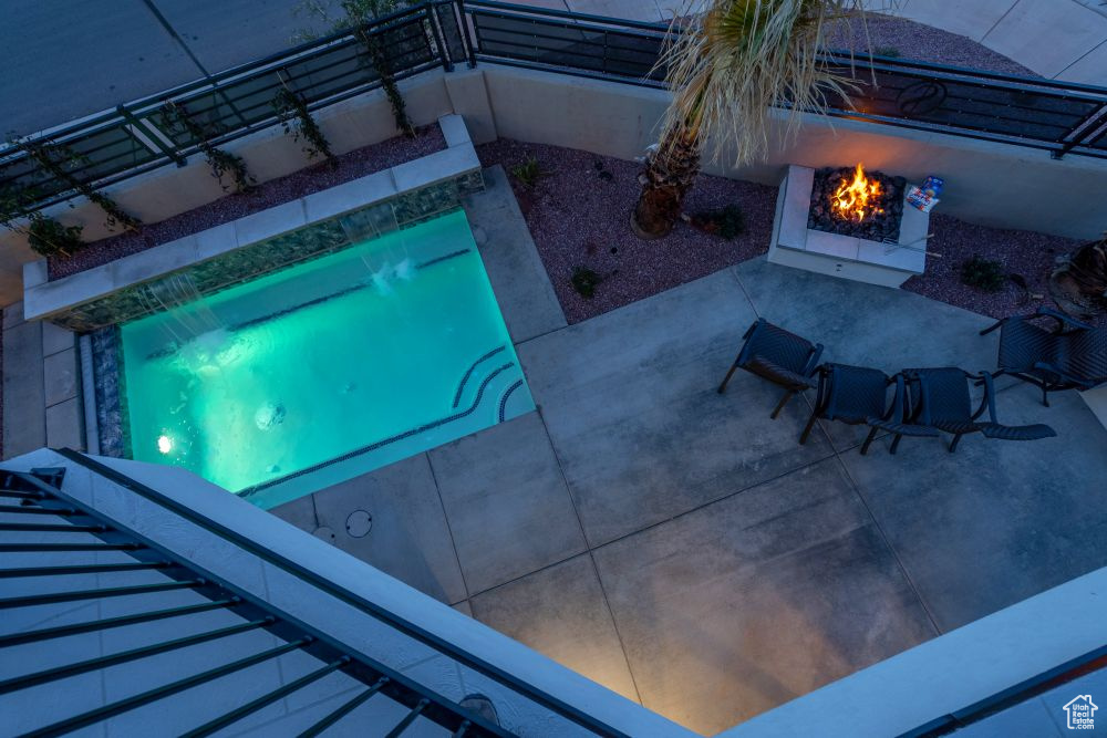 Outdoor pool featuring a patio and a fire pit