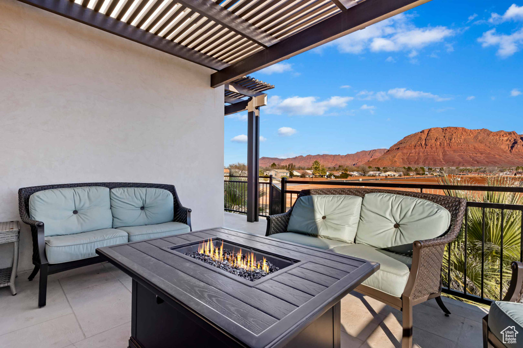 Balcony featuring a mountain view, a pergola, an outdoor living space with a fire pit, and a patio