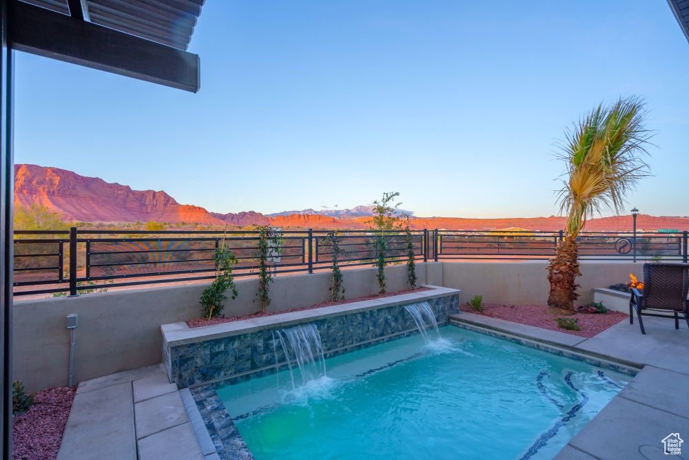 View of pool with a fenced in pool, a fenced backyard, a mountain view, and a patio