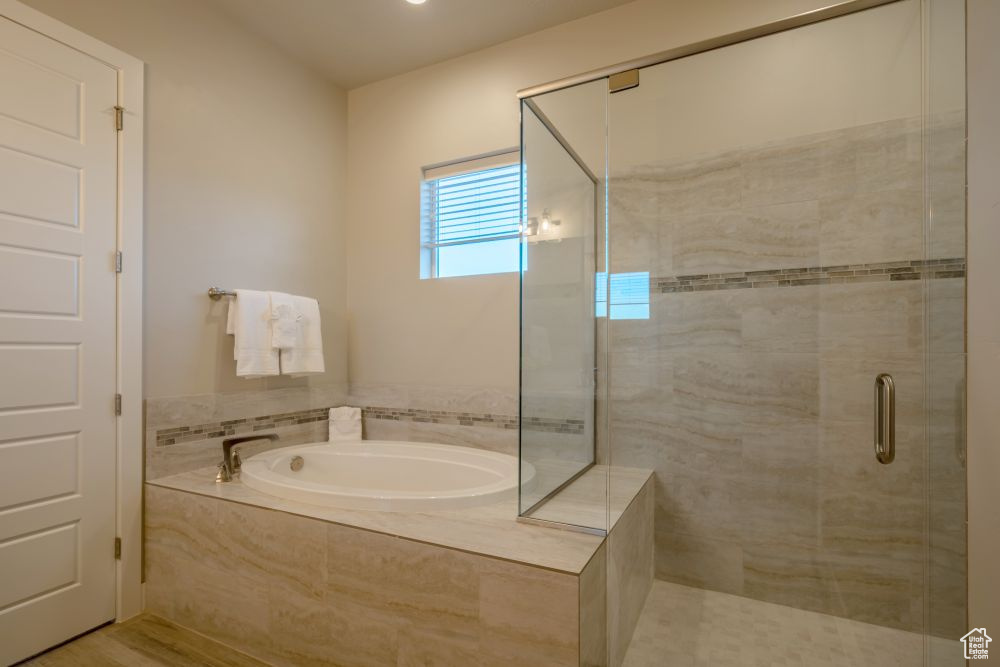 Bathroom featuring a shower stall and a bath