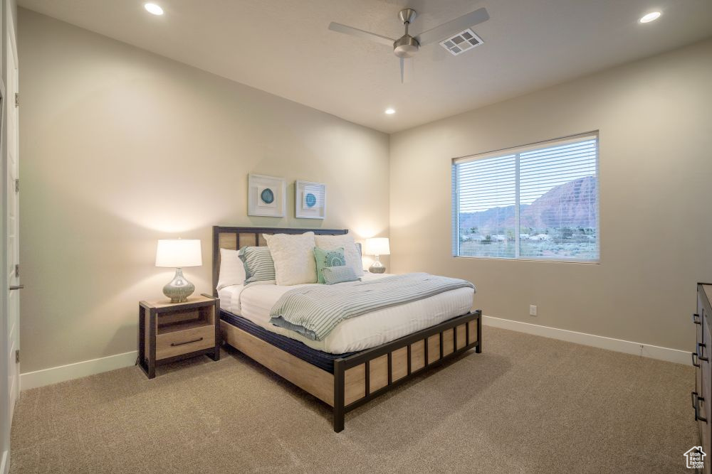 Bedroom with baseboards, light colored carpet, recessed lighting, and visible vents