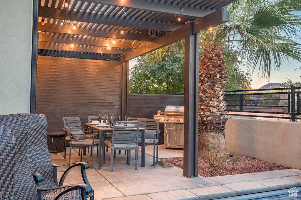 View of patio featuring a pergola, outdoor dining area, and fence