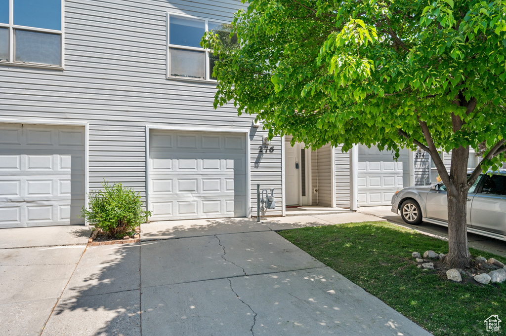 View of front of property featuring a garage and concrete driveway