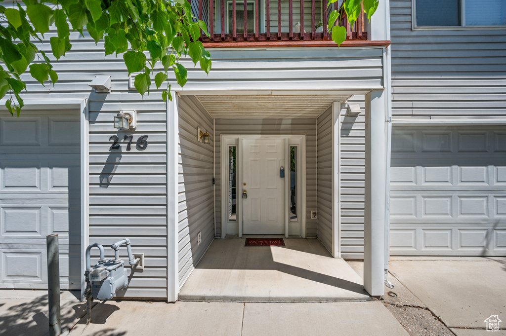 Doorway to property featuring a garage and a balcony