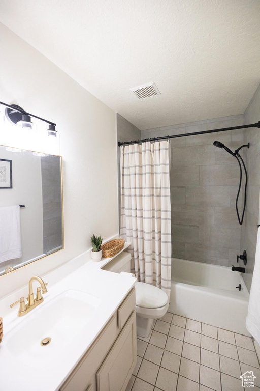 Full bathroom with tile patterned flooring, vanity, toilet, shower / tub combo, and visible vents