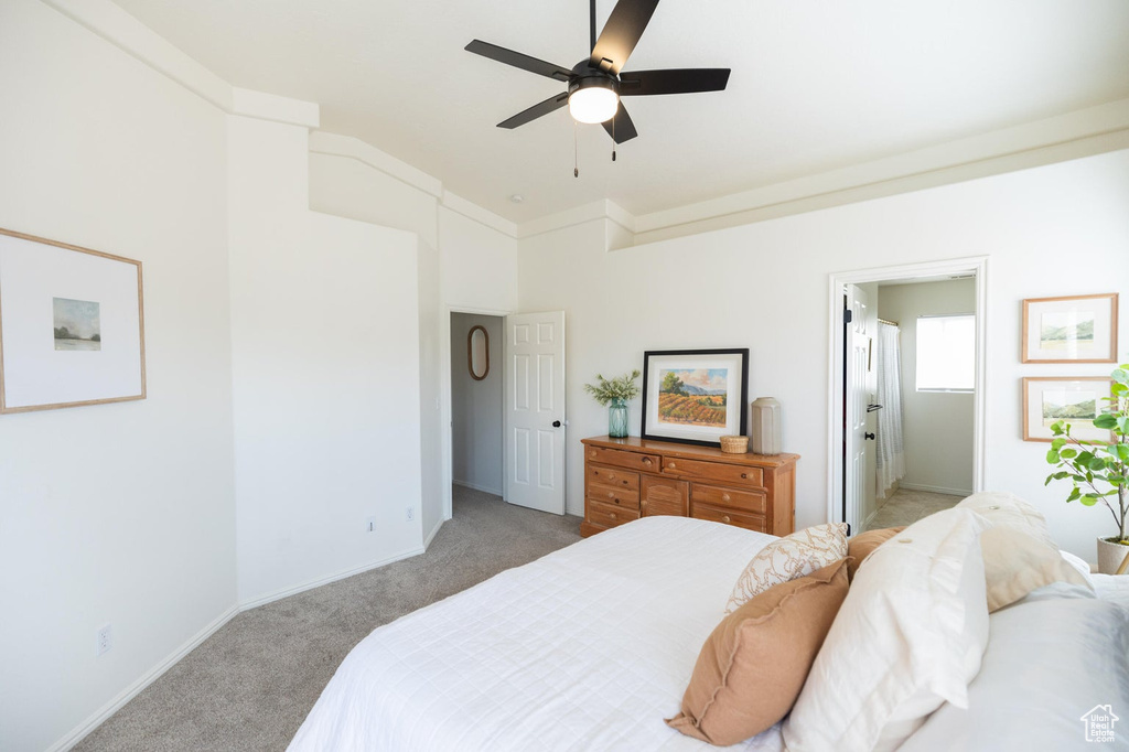 Bedroom featuring baseboards, ceiling fan, light carpet, and ensuite bathroom