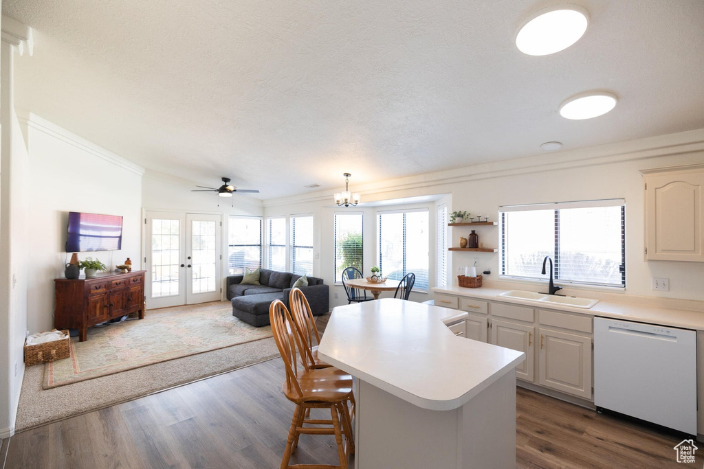 Kitchen with light countertops, a sink, dishwasher, and ornamental molding