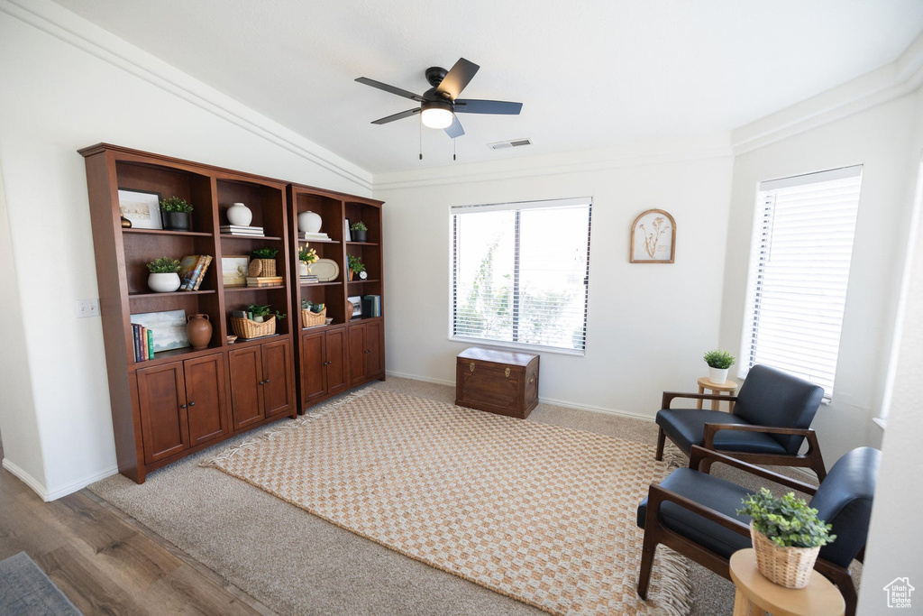 Sitting room with baseboards, ceiling fan, ornamental molding, and visible vents