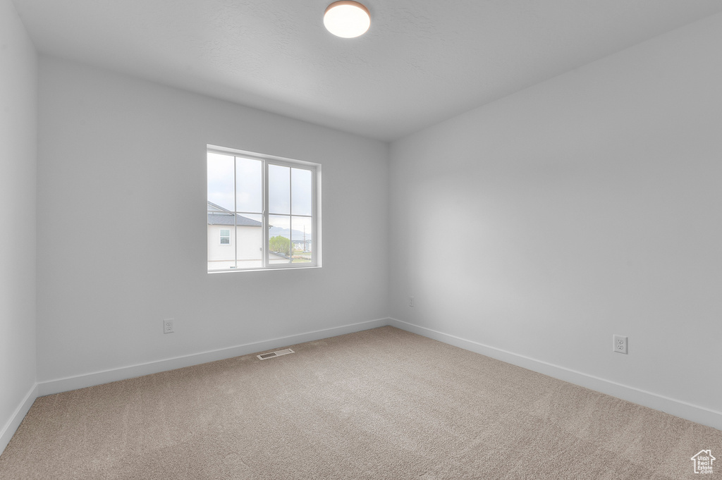 Carpeted spare room with baseboards and visible vents