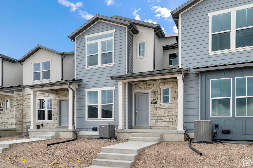View of front of property featuring central AC and stone siding