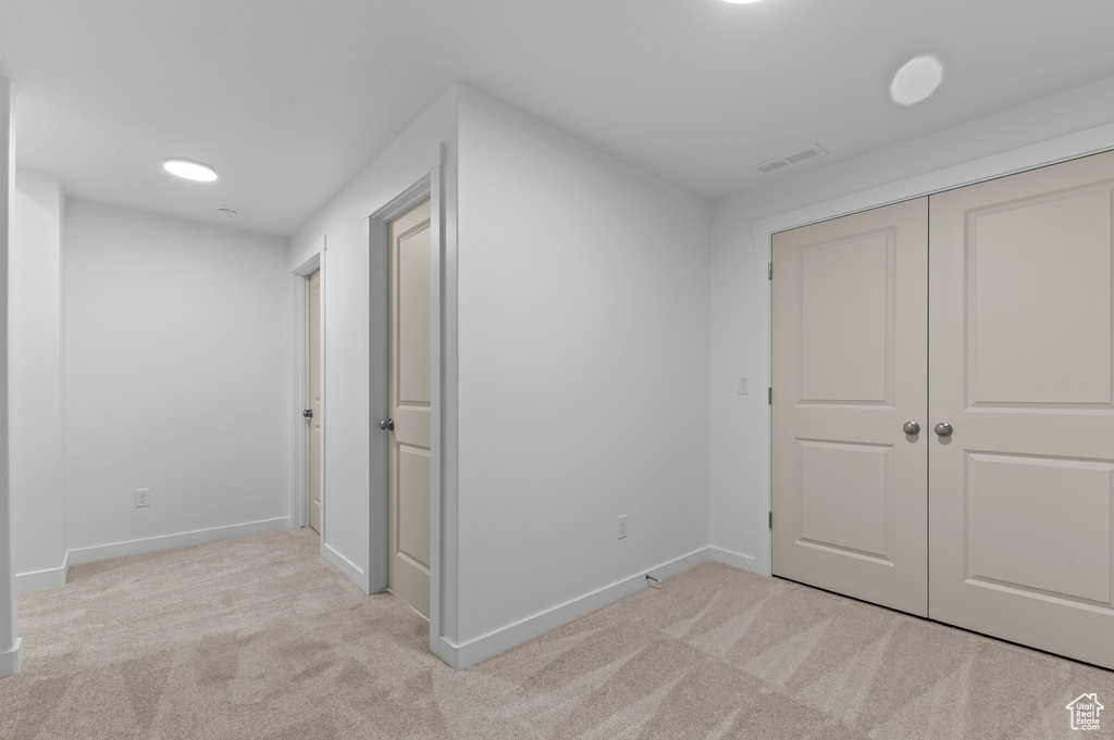 Unfurnished bedroom with baseboards, carpet flooring, visible vents, and a closet