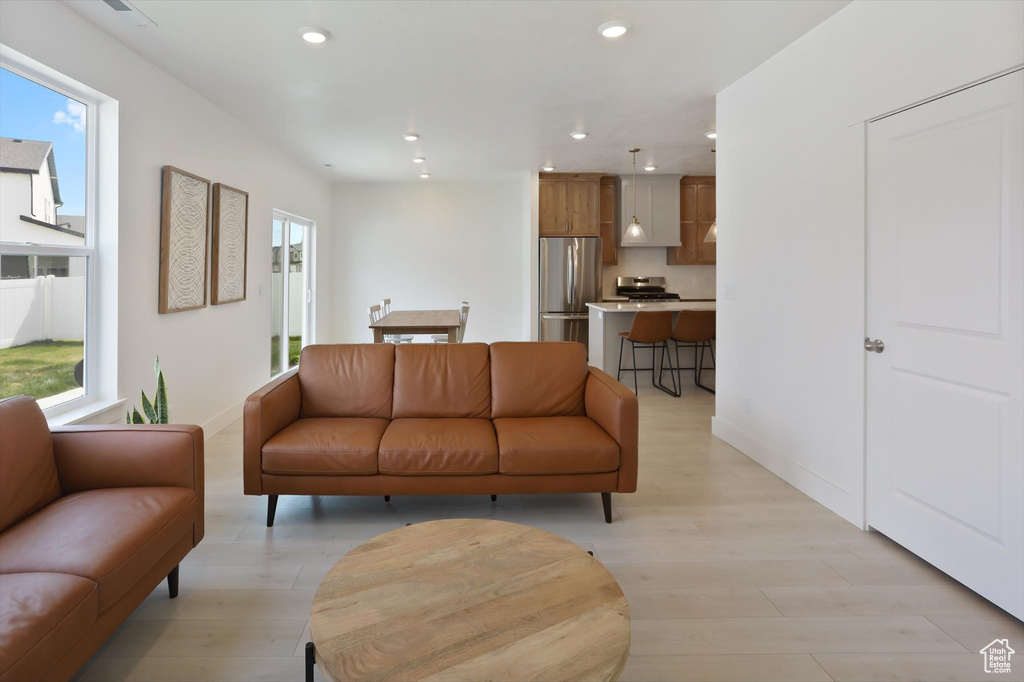 Living area featuring baseboards, recessed lighting, and light wood-style flooring