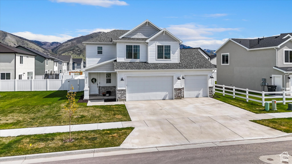 View of front of property featuring a front lawn, fence, a residential view, and concrete driveway