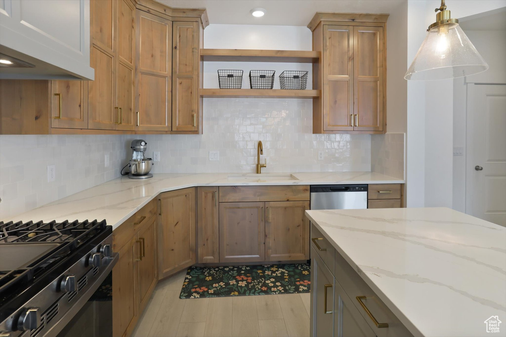 Kitchen featuring black range with gas cooktop, open shelves, a sink, and tasteful backsplash