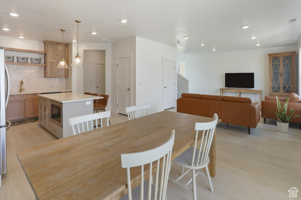 Dining room with light wood-style floors, recessed lighting, and visible vents