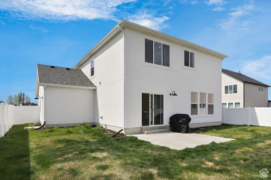 Back of house featuring a patio, stucco siding, and a yard