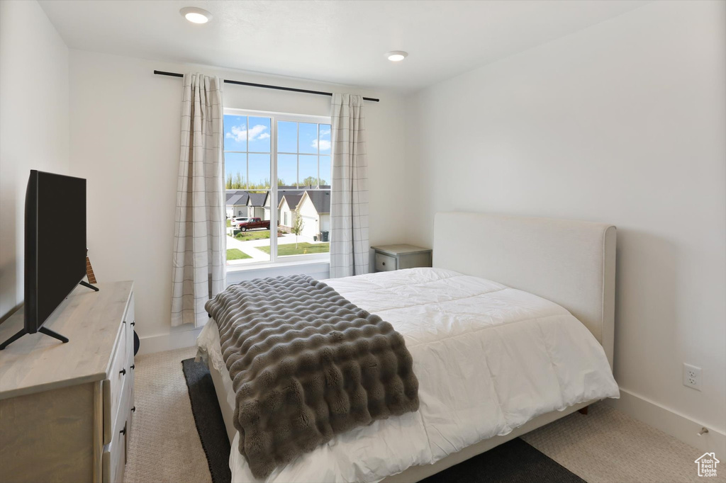 Bedroom with baseboards and light carpet
