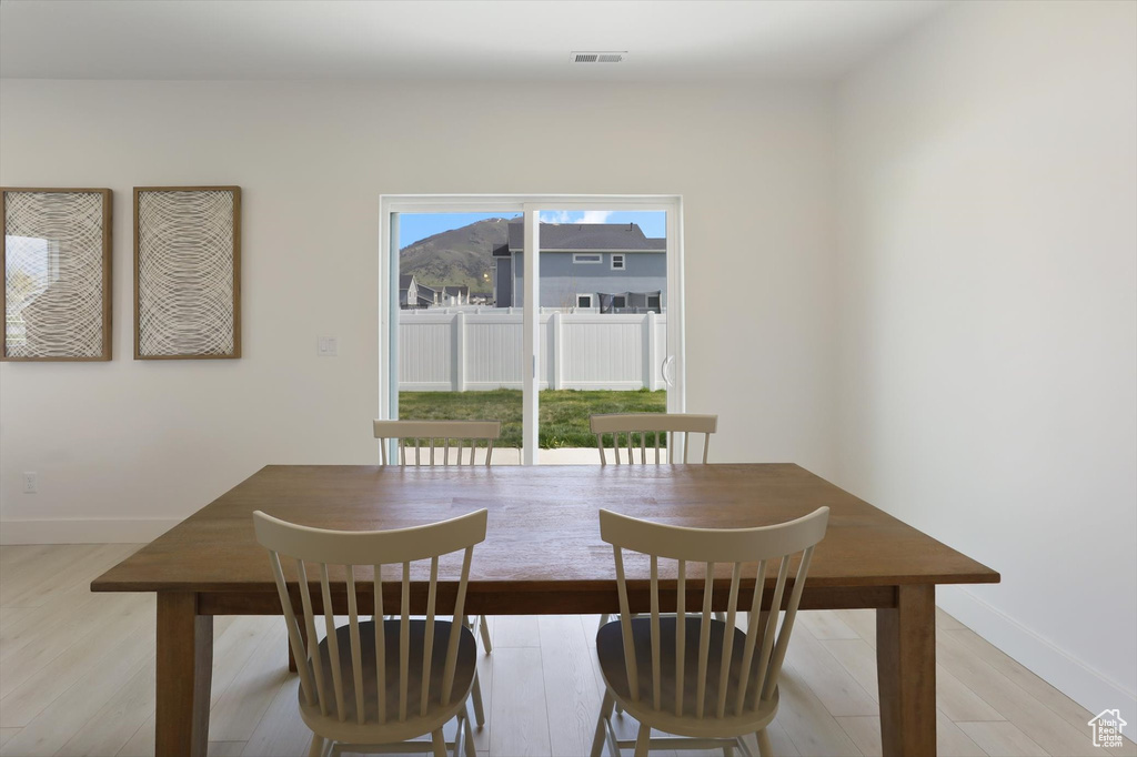 Dining room featuring light wood-type flooring, baseboards, and visible vents
