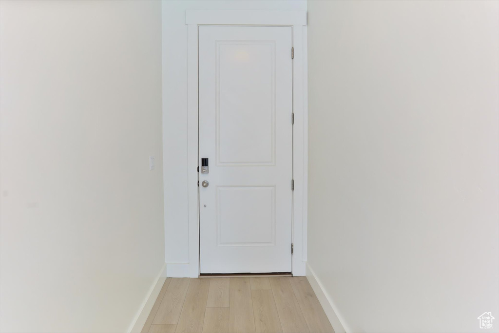 Doorway with baseboards and light wood finished floors