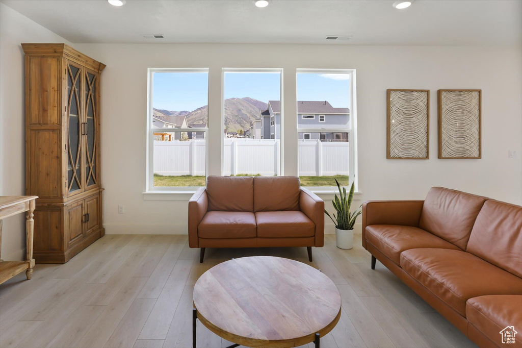Living area with recessed lighting, a healthy amount of sunlight, and light wood-style flooring