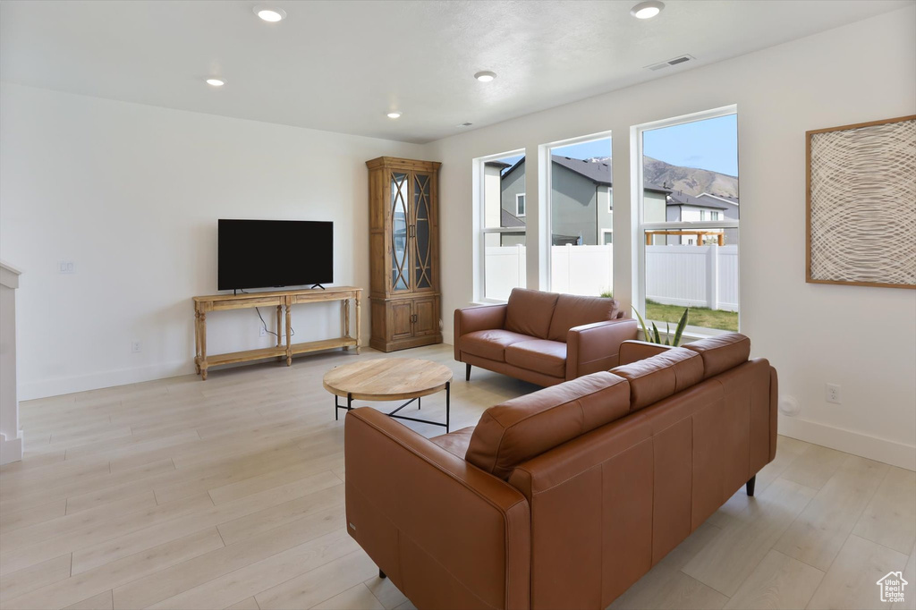 Living area featuring recessed lighting, baseboards, visible vents, and light wood finished floors