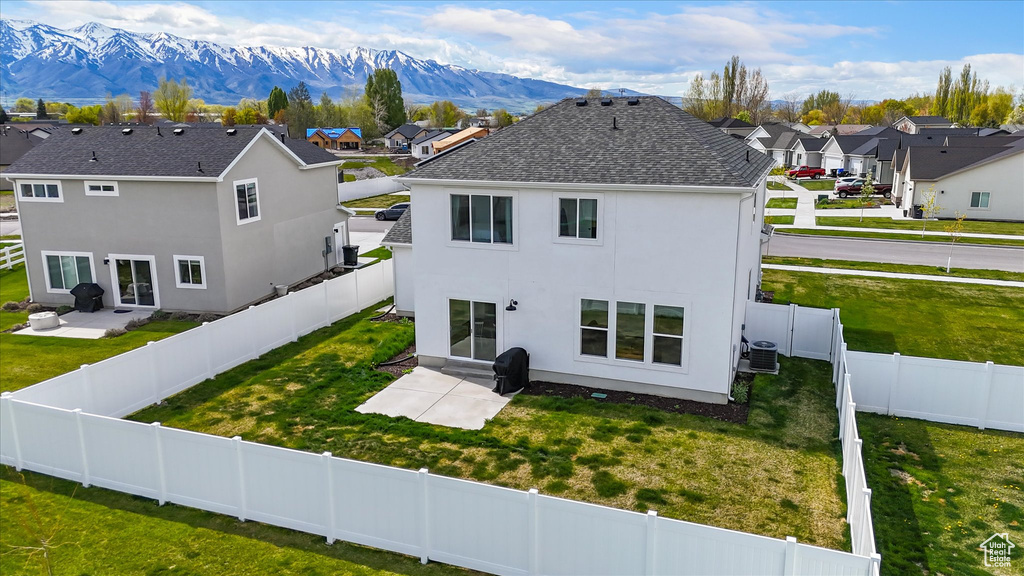 Back of house with a residential view, stucco siding, a mountain view, cooling unit, and a patio area