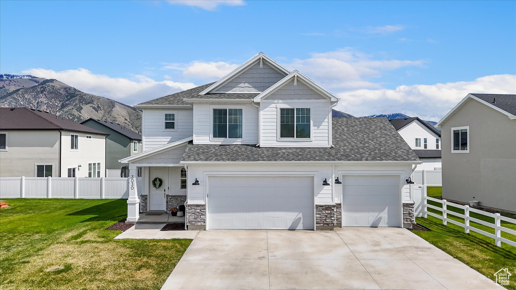 Craftsman house featuring a shingled roof, fence, driveway, and stone siding