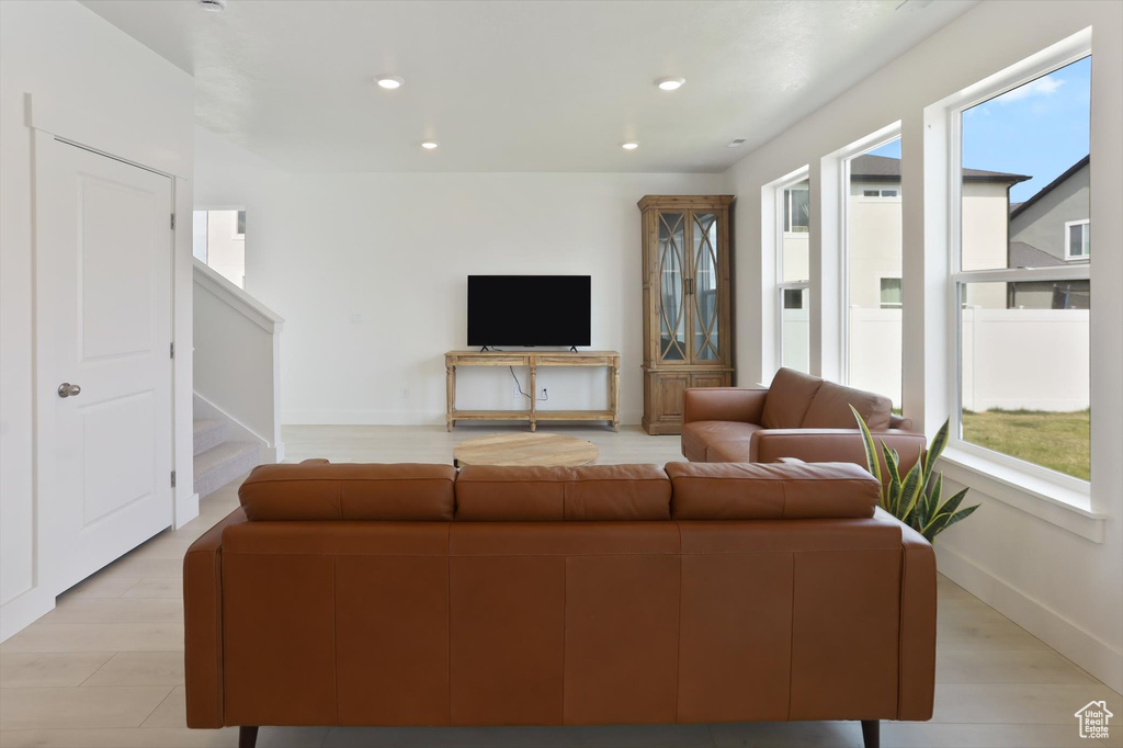 Living room featuring recessed lighting, baseboards, and stairs